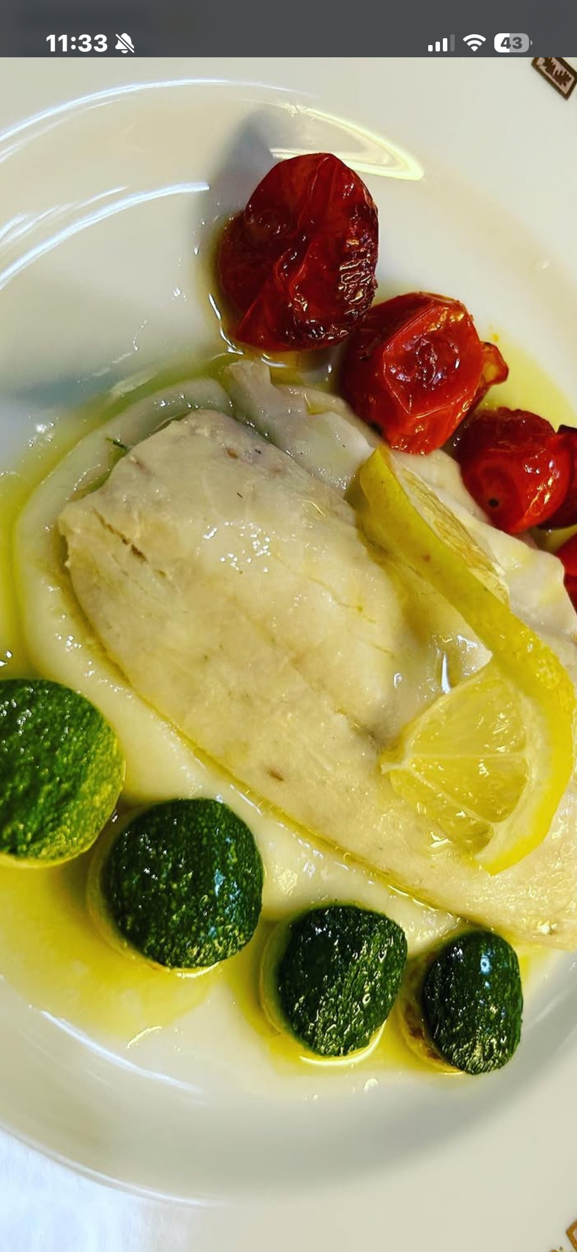 Poached fish with roasted tomatoes, lemon and zucchini