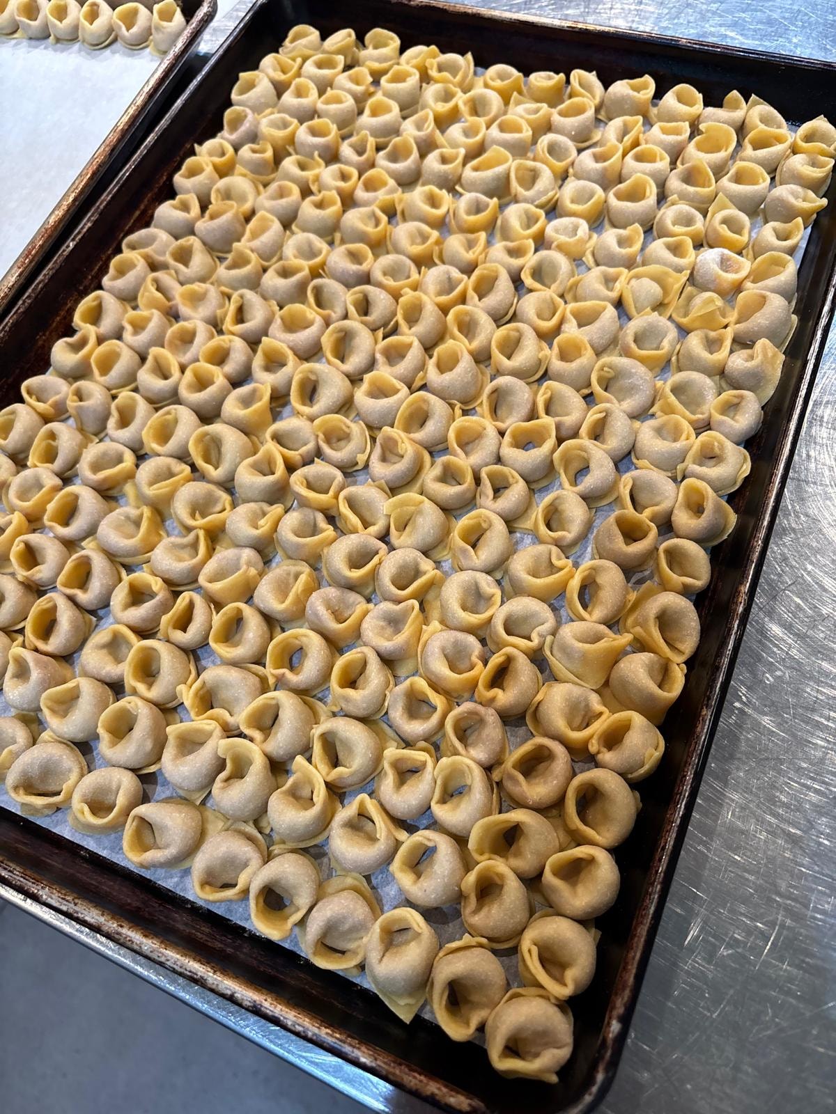Handmade dumplings arranged on a baking tray