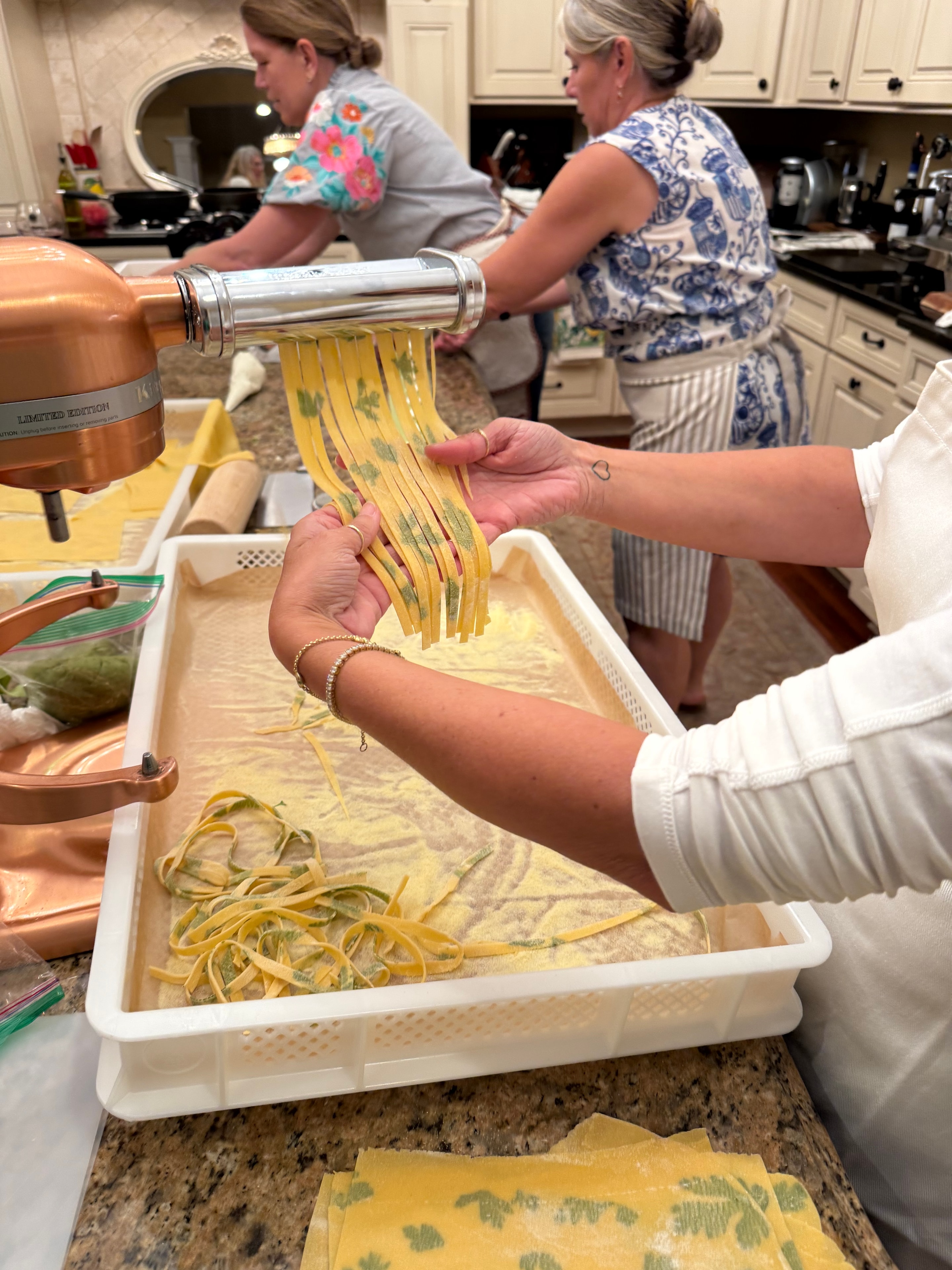 Women making fresh pasta together in a kitchen